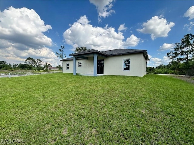 rear view of property with a yard