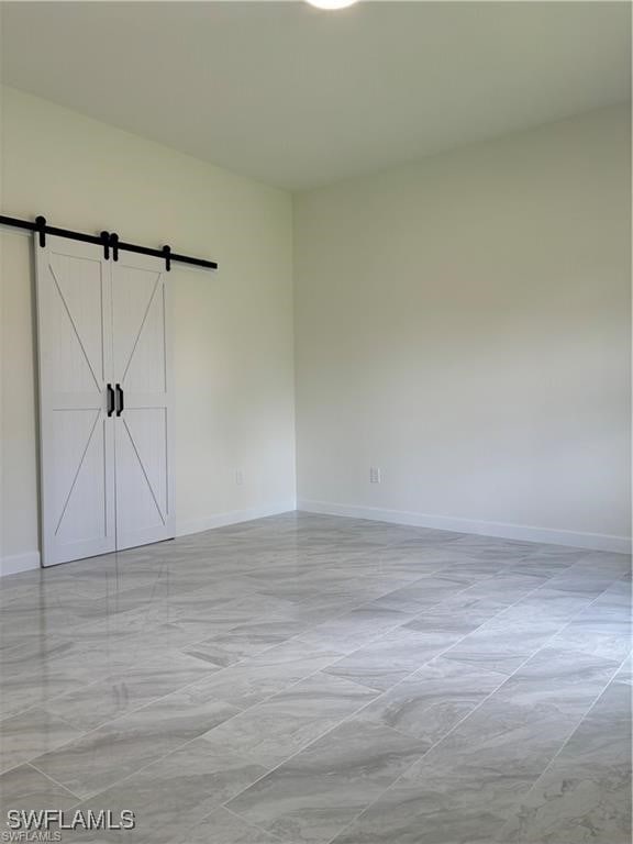 unfurnished room with a barn door