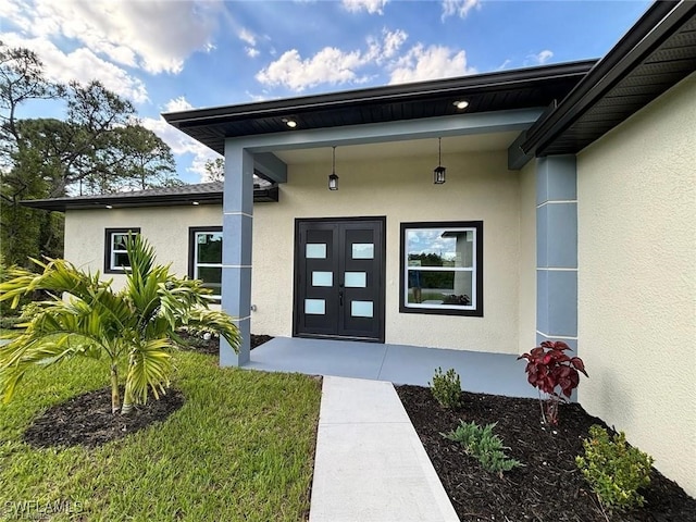 doorway to property with a lawn and french doors