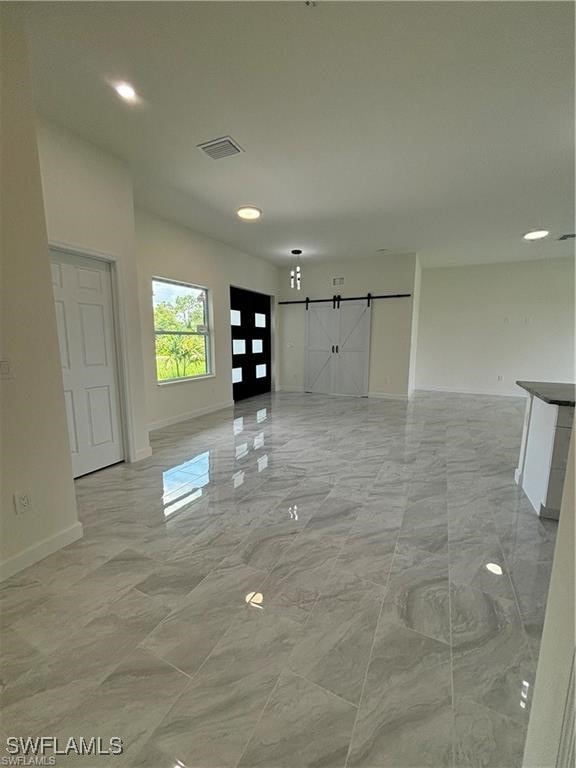 unfurnished living room with a barn door