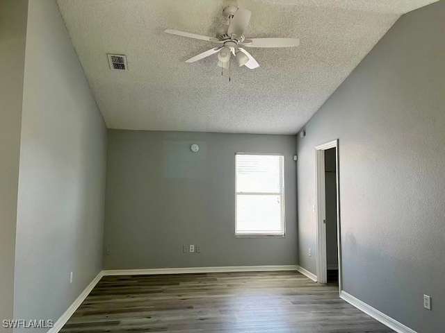 unfurnished room featuring vaulted ceiling, a textured ceiling, ceiling fan, and dark hardwood / wood-style floors