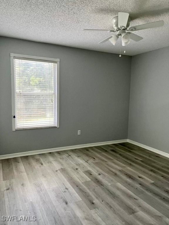 spare room featuring a textured ceiling, ceiling fan, and wood-type flooring