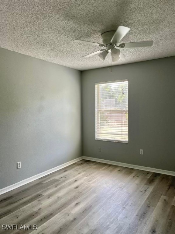 empty room with a textured ceiling, hardwood / wood-style floors, and ceiling fan