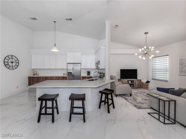 kitchen featuring white cabinets, stainless steel appliances, sink, a kitchen breakfast bar, and pendant lighting