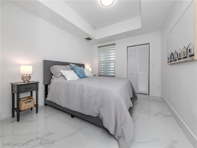 bedroom with a closet and a tray ceiling