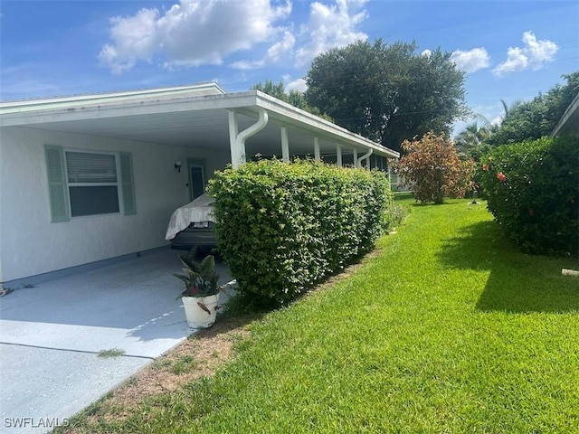 52 Heath Aster Ln, Lehigh Acres, FL 33936 - view of side of property featuring a lawn, an attached carport, and driveway