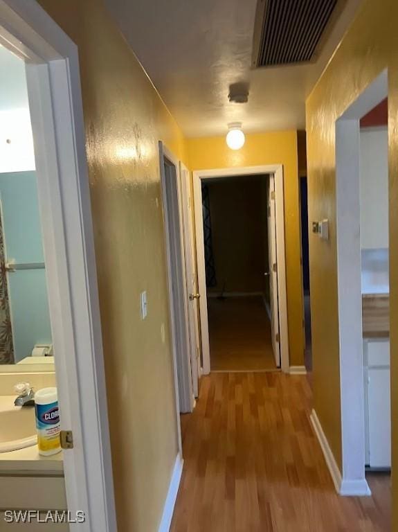 52 Heath Aster Ln, Lehigh Acres, FL 33936 - corridor with wood finished floors, baseboards, and a sink