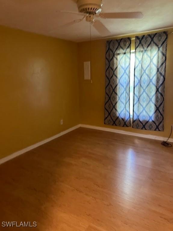 52 Heath Aster Ln, Lehigh Acres, FL 33936 - spare room featuring baseboards, a ceiling fan, and wood finished floors