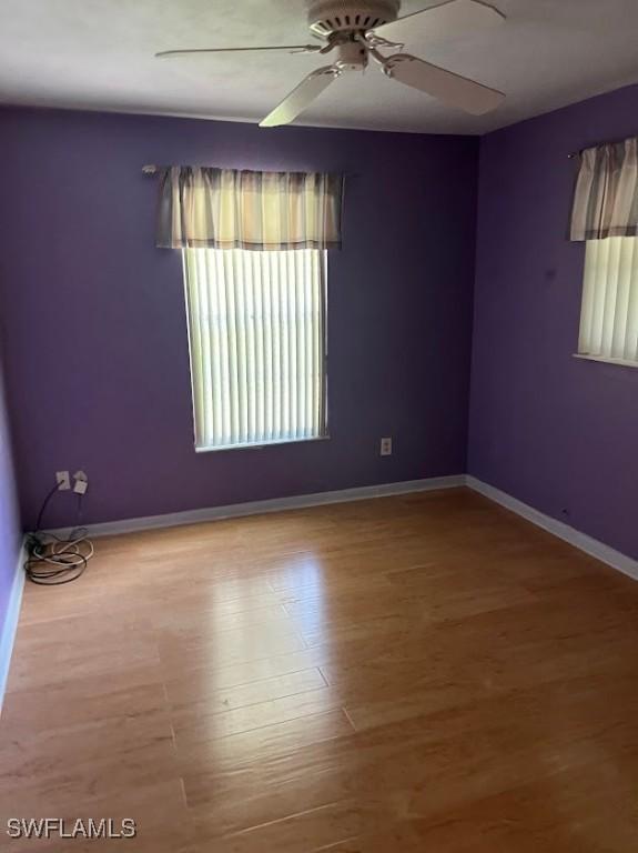 52 Heath Aster Ln, Lehigh Acres, FL 33936 - spare room featuring a ceiling fan, wood finished floors, and baseboards