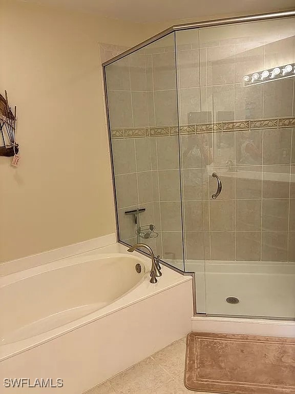 bathroom featuring tile patterned floors and separate shower and tub