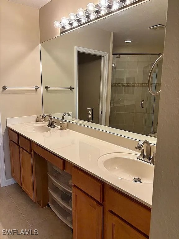 bathroom with vanity, a shower with shower door, and tile patterned flooring