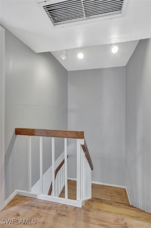staircase featuring visible vents, baseboards, and wood finished floors