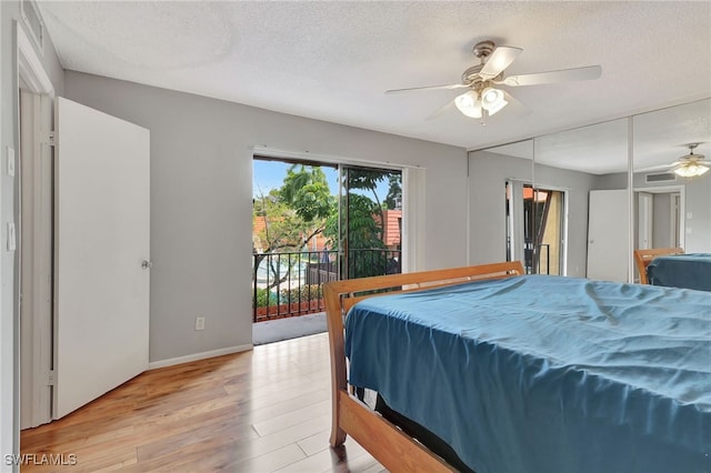 bedroom with ceiling fan, access to exterior, a textured ceiling, and light hardwood / wood-style flooring