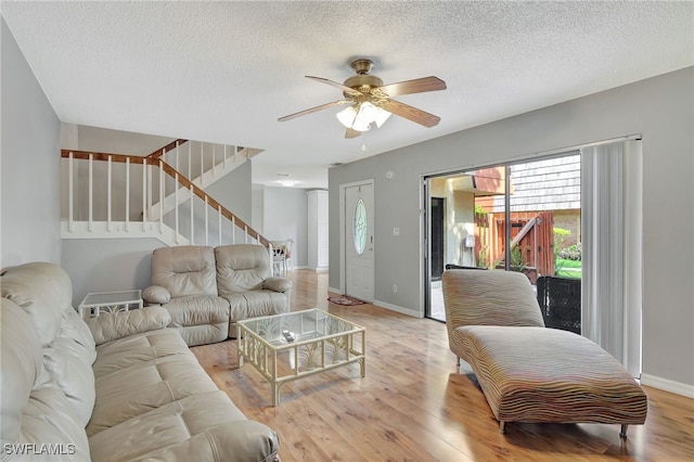 living room with light wood-type flooring, a textured ceiling, and ceiling fan