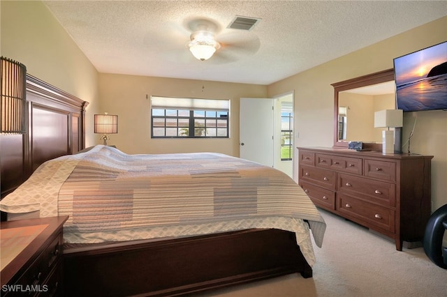 bedroom featuring ceiling fan, carpet floors, and a textured ceiling