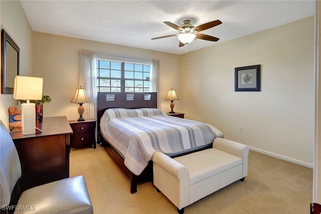 carpeted bedroom featuring a textured ceiling and ceiling fan