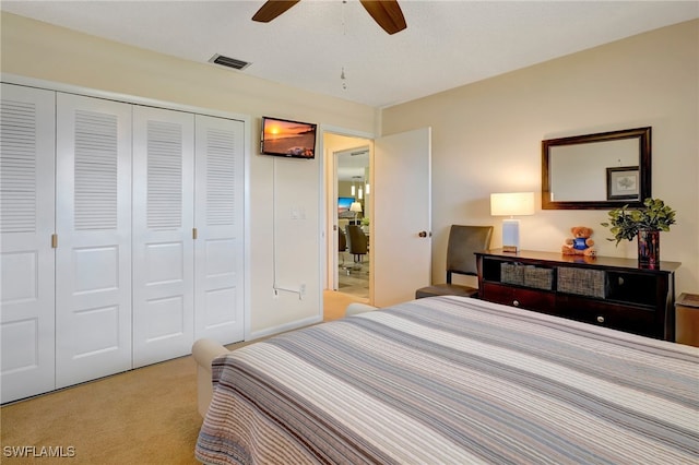 carpeted bedroom with a closet, ceiling fan, and a textured ceiling