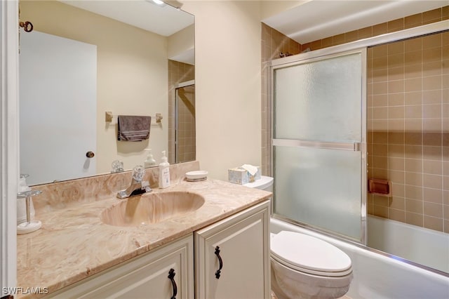 full bathroom featuring vanity, toilet, and bath / shower combo with glass door