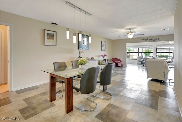 dining area with a textured ceiling, ceiling fan, and track lighting