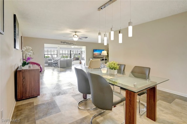 dining space with ceiling fan and track lighting