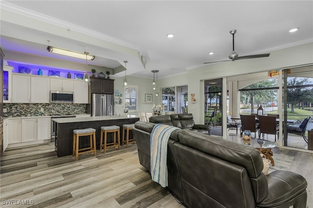 living room with ceiling fan, light hardwood / wood-style floors, and ornamental molding