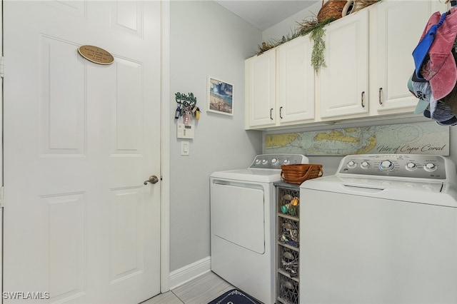 laundry room with separate washer and dryer and cabinets