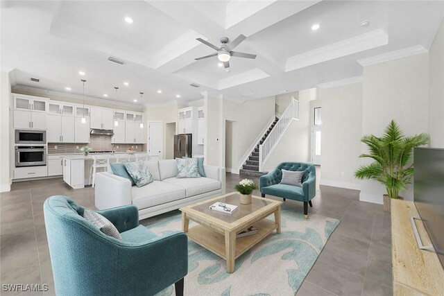 tiled living room with ornamental molding, ceiling fan, coffered ceiling, and beam ceiling