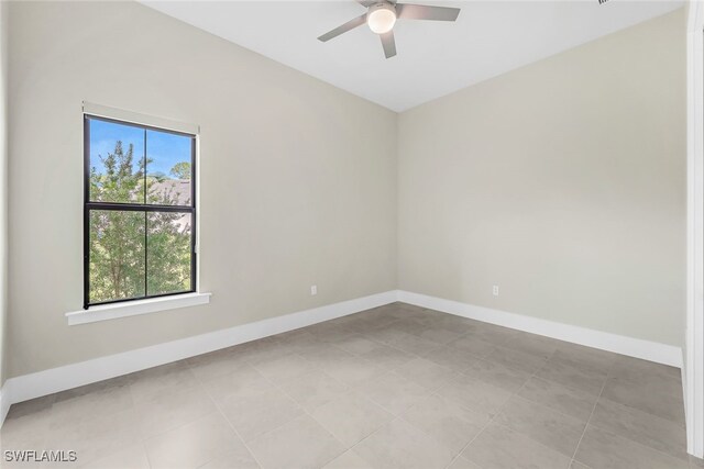 empty room featuring ceiling fan and light tile patterned floors