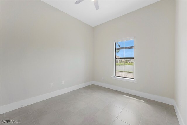 tiled spare room featuring ceiling fan