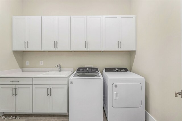 washroom with independent washer and dryer, cabinets, and sink