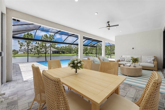 view of patio with a lanai, an outdoor hangout area, and a water view