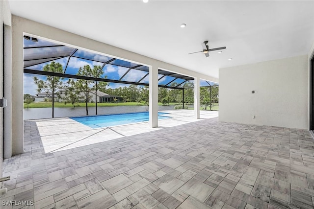 view of swimming pool featuring a lanai, a patio area, and a water view