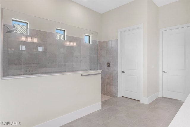 bathroom featuring tiled shower and tile patterned flooring