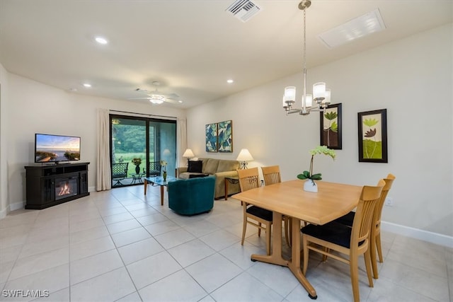 dining space with ceiling fan with notable chandelier and light tile patterned floors