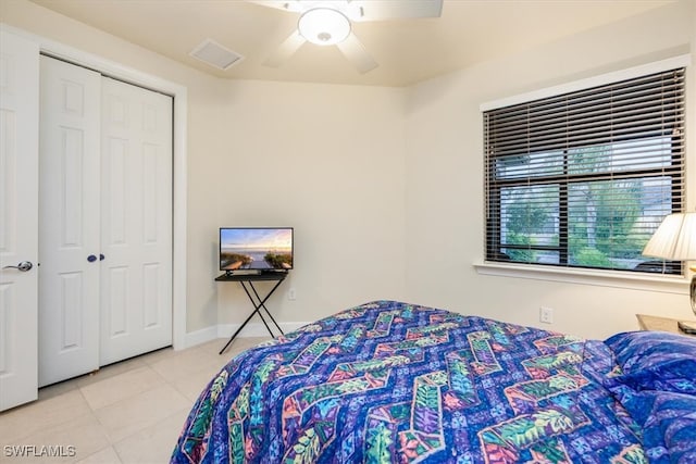 tiled bedroom with ceiling fan and a closet