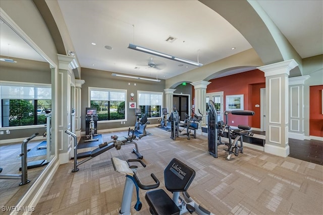 workout area featuring decorative columns and light carpet