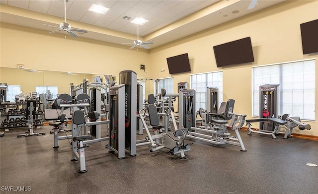 gym featuring plenty of natural light, a high ceiling, and ceiling fan