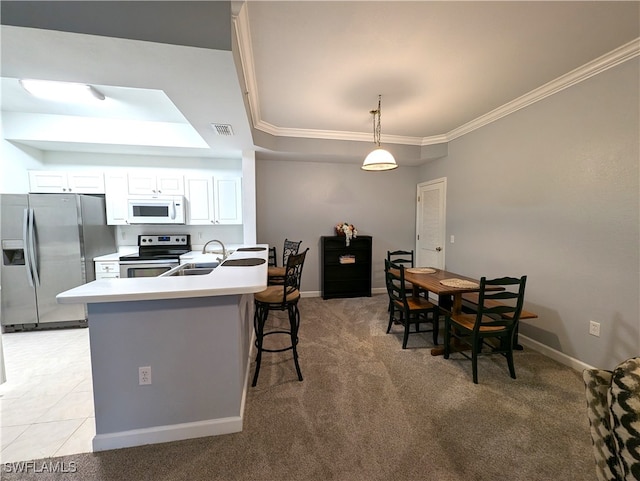 kitchen featuring light carpet, pendant lighting, white cabinetry, a breakfast bar, and appliances with stainless steel finishes