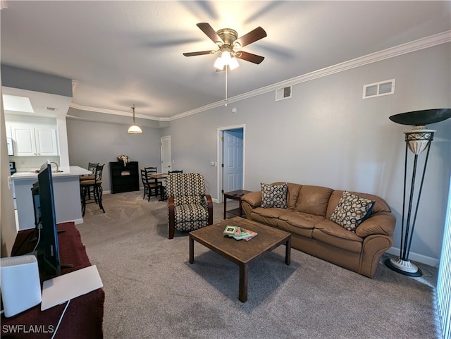 carpeted living room featuring ornamental molding and ceiling fan