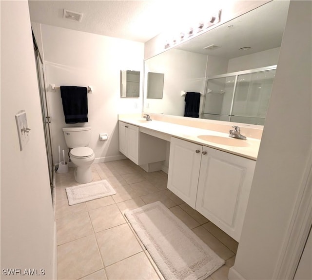 bathroom featuring a textured ceiling, vanity, walk in shower, toilet, and tile patterned floors