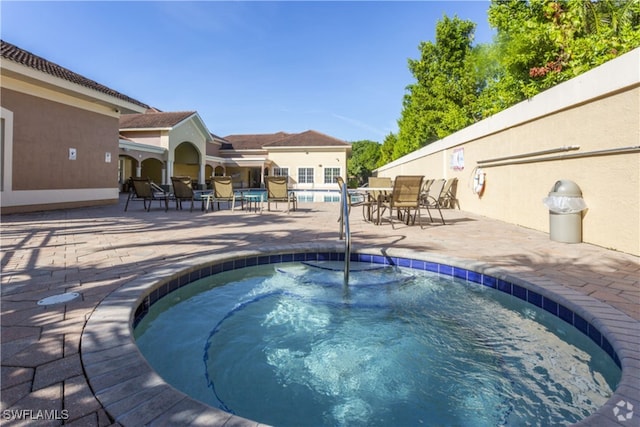 view of swimming pool with a hot tub and a patio