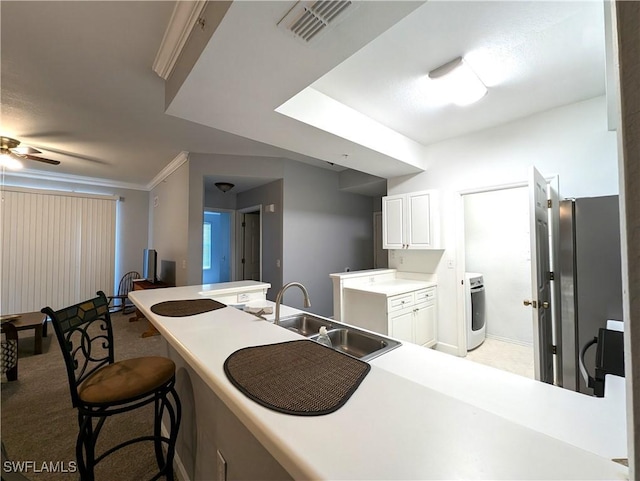 9005 Colby Dr Unit 1903, Fort Myers, FL 33919 - kitchen featuring visible vents, a sink, washer / dryer, freestanding refrigerator, and white cabinetry