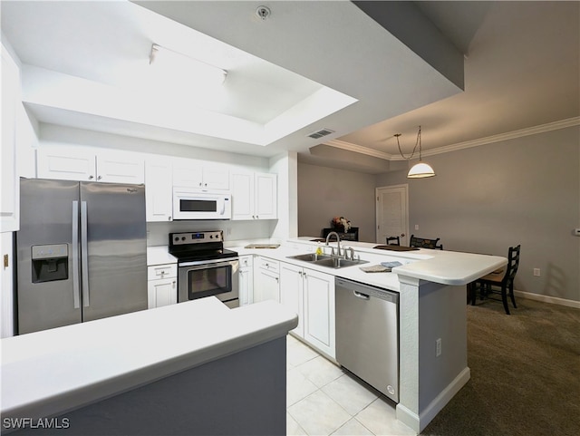 kitchen with decorative light fixtures, stainless steel appliances, sink, a tray ceiling, and kitchen peninsula