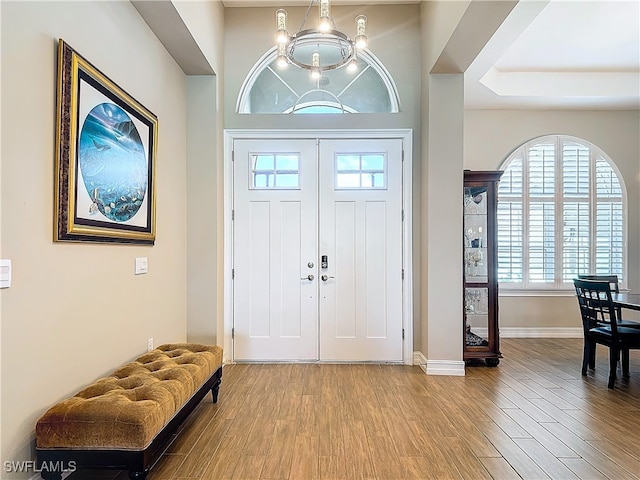 entrance foyer with hardwood / wood-style floors and an inviting chandelier