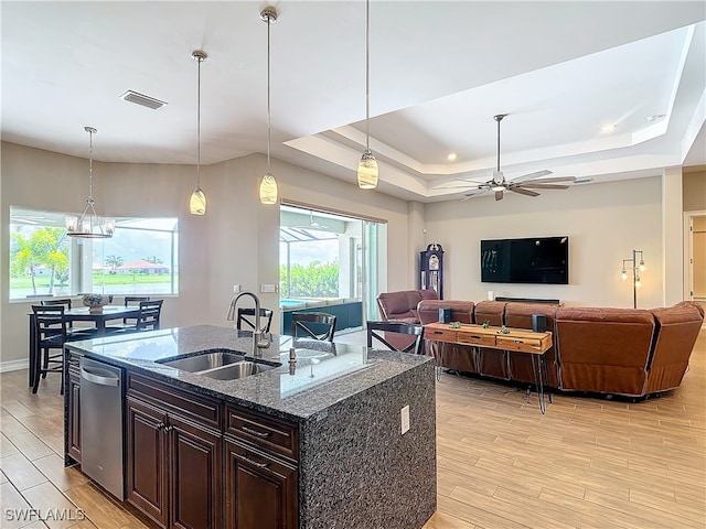 kitchen with decorative light fixtures, a wealth of natural light, and a kitchen island with sink