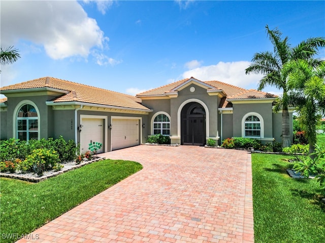 mediterranean / spanish-style home with a front yard and a garage