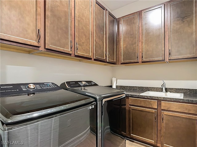 washroom with washer and clothes dryer, cabinets, and sink