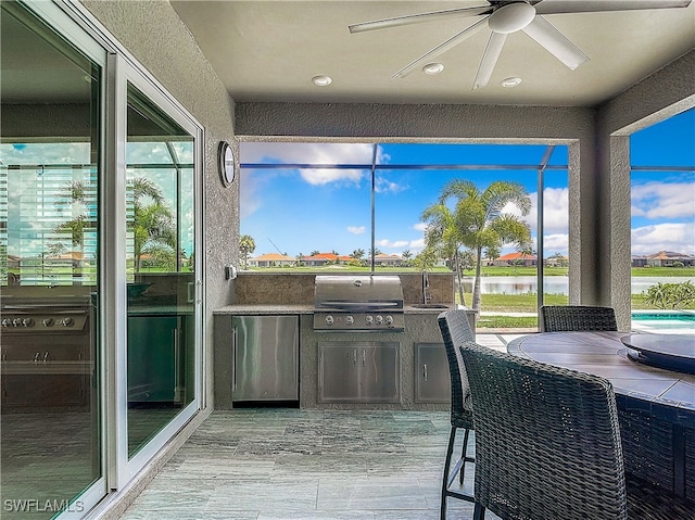 sunroom featuring a wealth of natural light, a water view, and ceiling fan