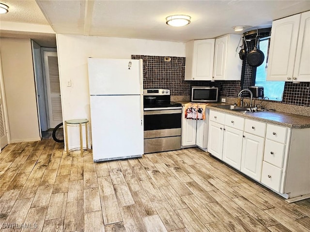 12474 Poem Ave, Punta Gorda, FL 33955 - kitchen with stainless steel appliances, light wood finished floors, decorative backsplash, and white cabinets