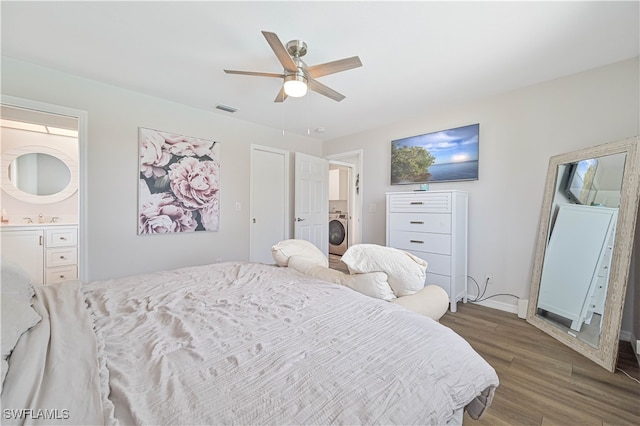 bedroom with connected bathroom, dark hardwood / wood-style flooring, sink, ceiling fan, and washer / dryer